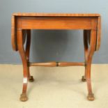 A satinwood sofa table, shaped end supports with carved paterae.