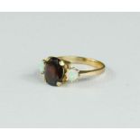 A 9ct gold ring set with oval garnet, flanked by two circular opals, size O, 3.6g.