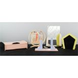 A group of bakelite vintage items including mirror, box, stand, and circular frame.