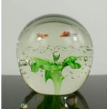 A Murano glass paperweight with green flower and two bees.