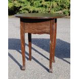 A circular top oak sewing table.