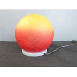 A red and yellow spherical table lamp.