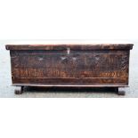 A stained pine blanket chest, with a carved front.