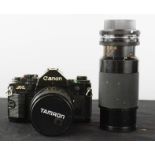 A Canon camera with two Tamron lenses.
