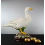 A model duck, with three golden eggs.