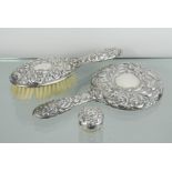 A silver hand mirror and brush embossed with decoration, together with a dressing table pot with