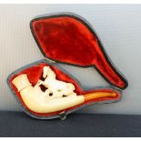 A Meerschaum pipe carved with a horse, with amber tip, in a case.