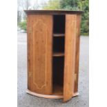 A small oak bow front corner cupboard.