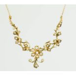 A 15ct gold and seed pearl necklace; the central flowerhead flanked by foliate spray links and