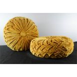A pair of yellow velvet retro boulder cushions.