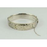CATALOGUE AMENDMENT * A silver bangle with chased floral design, London 1965.