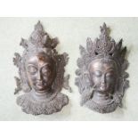 A pair of bronzed Indian Goddess heads.