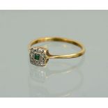 An 18ct gold ring set with emerald and chip diamonds, size R/S