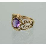 A 9ct gold and amethyst ring, the decoratively pierced sides set with a central oval cut amethyst,