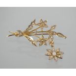 A yellow metal and seed pearl brooch in the form of a floral spray with pendant flower, 4.4g.