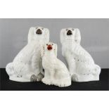 A pair of Staffordshire dogs and another. (3)