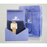 A Swarovski wristwatch, with leather strap, square face, in the original box with certificate.