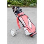 A complete set of golf clubs and trolley.