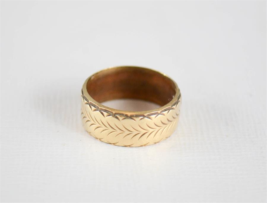 A 9ct gold ring, with 'feathered' engraved decoration, 4.3g.