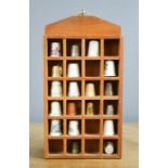 A collection of thimbles together with its wall display stand.
