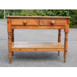 A Victorian pine two drawer side table.
