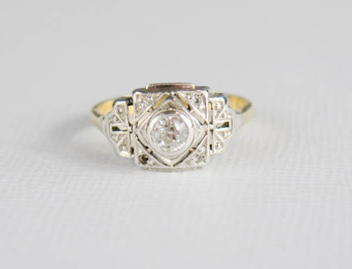 An early 20th century Art Deco style ring with central diamond, set in platinum setting, on an