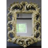 A large painted wall mirror, with boldy carved scrollwork frame, 120 by 90cm.