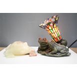 An onyx model frog, and a table lamp with coloured glass shade, the base in the form of two frogs.