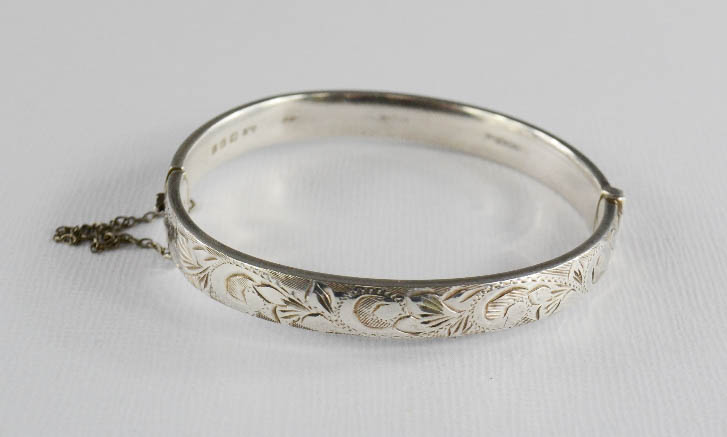 A silver bangle with chased design, GJ maker.