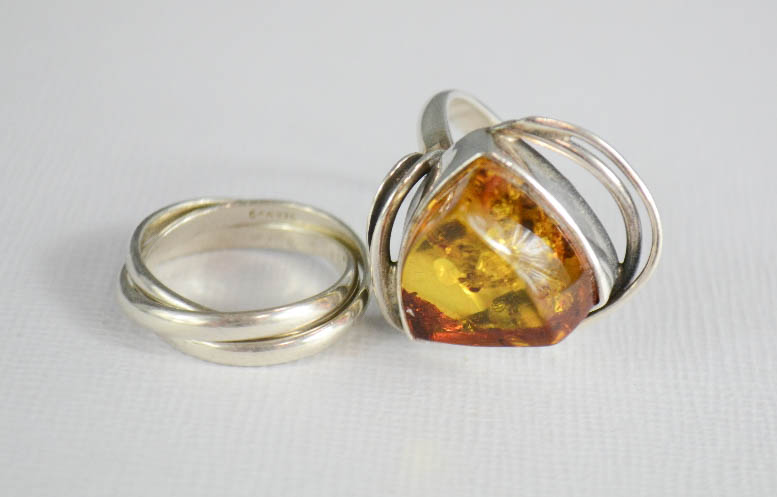 A silver and amber ring, and a silver Russian three band wedding ring.