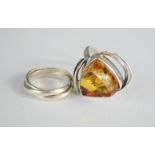 A silver and amber ring, and a silver Russian three band wedding ring.