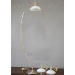 An arched brass lamp standard together with matching wall lights.