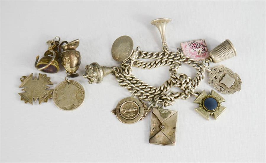 A silver fob bracelet, with silver and other charms.