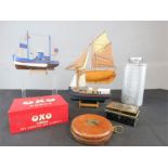 A group of tins, boats, and a leather tape measure.