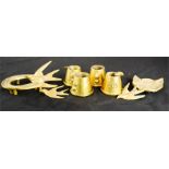 A group of four trench art ash trays together with brass cat head, three swallows, two horseshoes.