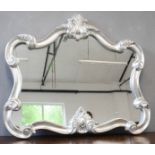 A modern silver gilt wall mirror, with scrollwork frame, 97 by 108cm.