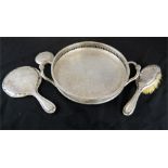 A silver plated circular wine tray, engraved with chased decoration, a silver mirror and brush,