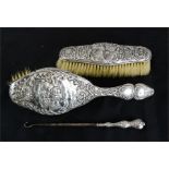 A silver clothes brush, hair brush, and button hook, embossed with cherubs.
