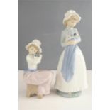 Two Nao Lladro figures; young girls holding puppies.