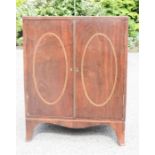 A mahogany two door cabinet, two doors inlaid with ovals, bracket feet, 76 by 43 by 60cm.