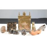 A group of collectables, including a brass fireplace, cat, a group of model antique shoes, and a
