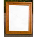 A large pine wall mirror, with deeply moulded frame.