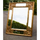 A giltwood wall mirror, with pierced and carved decorated corners.