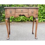 An 18th century walnut lowboy, with three drawers, shaped apron and cabriole legs.