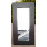 A large wall mirror, with wide black frame.