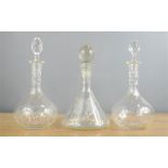 Three glass decanters, one engraved with a fox head.