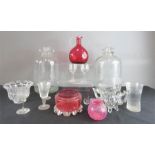 A group of glassware including two demi johns, a cranberry glass jug etc.