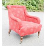 An Edwardian low armchair, mahogany framed, and upholstered in red.