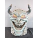 A large grey devil mask.