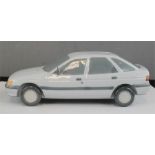 A Lladro ceramic model of a Ford Escort, 1990. 29cm long.